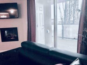 a living room with a couch and a fireplace and a window at 2 BDRM A/C Condo w/Ensuite Laundry + Free Parking in Edmonton