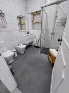 biała łazienka z 2 toaletami i prysznicem w obiekcie Casa das Palmeiras - Res. of Elizabete and Fatima w mieście Horta