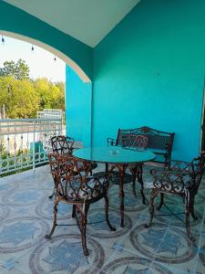 a table and chairs in a room with a blue wall at Casa Bonzay in Bacalar