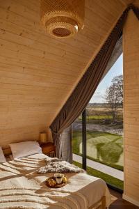 - une chambre avec un lit et une grande fenêtre dans l'établissement Wood House Trzęsacz, à Trzęsacz