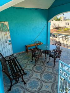 una mesa y sillas en un balcón con una pared azul en Casa Bonzay, en Bacalar
