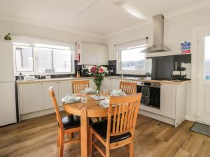 a kitchen with a wooden table and chairs in a kitchen at Rothiemay in Girvan