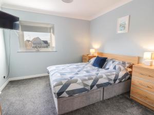 a bedroom with a bed and a window and a television at Rothiemay in Girvan