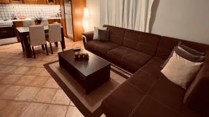 a living room with a brown couch and a table at CW Flat in Alexandroupoli