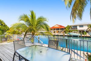 a table and chairs on a deck next to a body of water at Ninth Street Getaway in Key Colony Beach