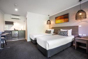 Habitación de hotel con 2 camas y cocina en Doncaster Apartments by Nightcap Plus, en Doncaster