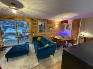 ein Wohnzimmer mit einem blauen Sofa und einem Tisch in der Unterkunft les Airelles 202 in Les Carroz d'Araches