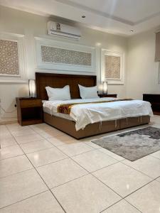 um quarto com uma cama grande e duas mesas de cabeceira em منازل المرجان للوحدات السكنية المفروشة Manzel Al Murjan Hotel Apartments em Riade