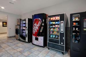 three soda machines are lined up against a wall at Motel 6-Pharr, TX in Pharr