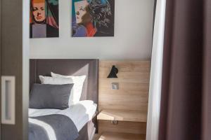 - une chambre avec un lit et 2 photos sur le mur dans l'établissement Best Western Hotel Halland, à Kungsbacka