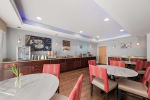 a restaurant with two tables and chairs and a counter at SureStay Plus Hotel by Best Western Plano in Plano