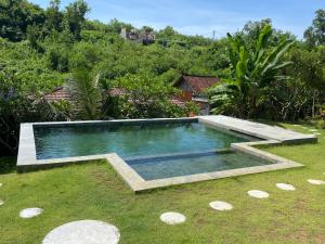 a swimming pool in the yard of a house at Belong Bunter Homestay in Uluwatu