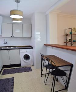 a kitchen with a table and a washing machine at Casa De La Paz in Ronda