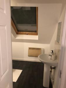 a bathroom with a sink and a tv on the wall at 1 bedroom flat Oakfield Road in Bristol