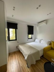una camera con un letto e un divano giallo di Digital Nomad Central ap a Tirana