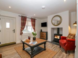 a living room with a table and a fireplace at Thomas Cottage in Wotton under Edge