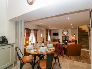 een eetkamer en een woonkamer met een tafel en stoelen bij Thomas Cottage in Wotton under Edge