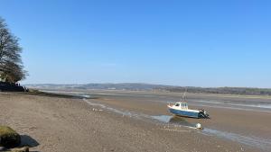 a boat sitting on the shore of a beach at Arnside sea view in Arnside
