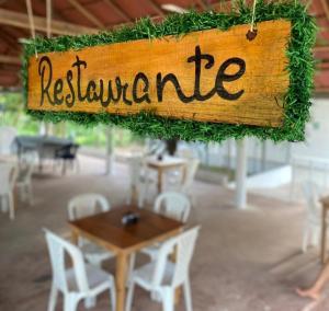 un panneau en bois avec le mot restaurant suspendu au-dessus d'une table dans l'établissement Finca Hotel Villa Manuela, à Sahagún