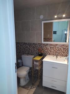 ein Badezimmer mit Toilette, Waschbecken und Spiegel in der Unterkunft Cabañas Mundo al revés in La Silleta