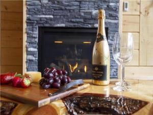 a bottle of champagne and a wine glass on a table at Chalet l'amical avec Spa in Saint-Philémon