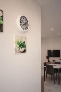 a clock hanging on a wall above a table at [Chiaia] Arcoleo House - Anita in Naples