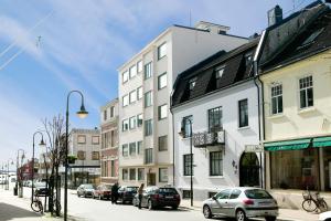 a city street with cars parked in front of buildings at Apartment gågata in Kristiansand