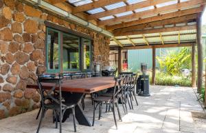 Un patio al aire libre con una mesa y sillas de madera. en Casa Rua Margaret River, en Witchcliffe