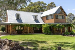 a house with a metal roof on top of a yard at Casa Rua Margaret River in Witchcliffe