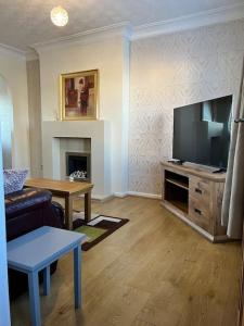 a living room with a couch and a television at Home Away in Wigan