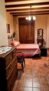 a bedroom with a bed and a dresser in a room at El Alambique in Cazorla