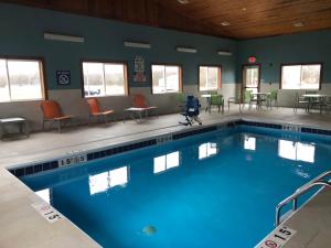 a swimming pool in a gym with chairs and tables at Holiday Inn Express Mt. Vernon by IHG in Mount Vernon