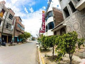 an empty city street with a hotel sign and trees at Hotel Sol de Oro Ayacucho in Ayacucho