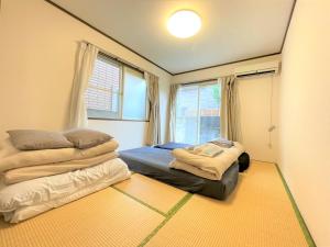 a bedroom with two beds and a window at Estate F101 in Kamatachō