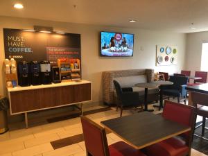 a restaurant with tables and chairs and a tv on the wall at Holiday Inn Express Mt. Vernon by IHG in Mount Vernon