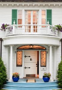 Biały dom z dwoma niebieskimi doniczkami na drzwiach wejściowych w obiekcie Hampton Terrace Inn w mieście Lenox