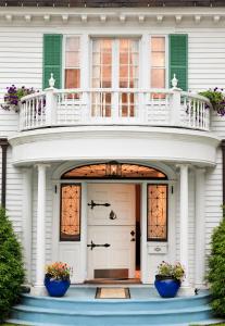 a white house with two blue flower pots on the front door at Hampton Terrace Inn in Lenox