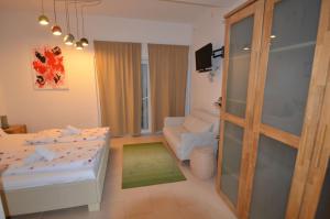 ein Schlafzimmer mit einem Bett und ein Wohnzimmer in der Unterkunft Am Schlosspark - App Seestern in Glücksburg