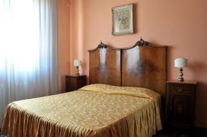 フィレンツェにあるレジデンツァ カンタガリのベッドルーム1室(木製ヘッドボード付きのベッド1台付)