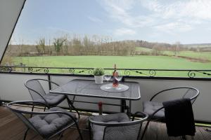 a table and chairs on a balcony with a view of a golf course at Daddeldu in Klenzau