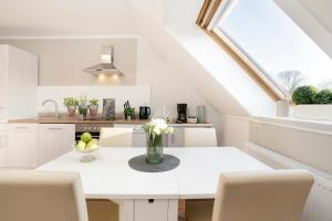 a white kitchen with a table and chairs at Daddeldu in Klenzau