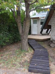 una pasarela de madera junto a un árbol frente a una casa en Hermosa cabaña en la entrada de San martín de Los Andes en San Martín de los Andes