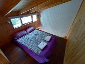 Dormitorio pequeño con cama morada en una cabaña en Hermosa cabaña en la entrada de San martín de Los Andes en San Martín de los Andes