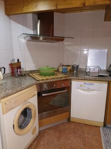 a kitchen with a washing machine and a dishwasher at Casa do Soito. in Avelãs de Ambom