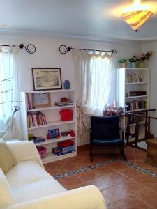 sala de estar con sofá blanco y silla en Costa da Caparica Beach House, en Costa da Caparica