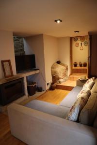 a living room with a couch and a tv at Casa do Soito. in Avelãs de Ambom