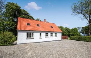 una pequeña casa blanca con techo naranja en Beautiful Home In Sams With Kitchen, en Toftebjerg