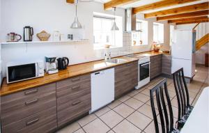 cocina con armarios de madera y nevera blanca en Beautiful Home In Sams With Kitchen, en Toftebjerg