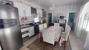 a kitchen with a table with chairs and a refrigerator at Casa Beira Mar Mariscal 1 in Bombinhas