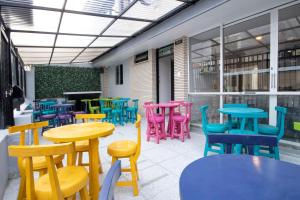 a group of colorful tables and chairs on a patio at Urbana Hostel in Bogotá